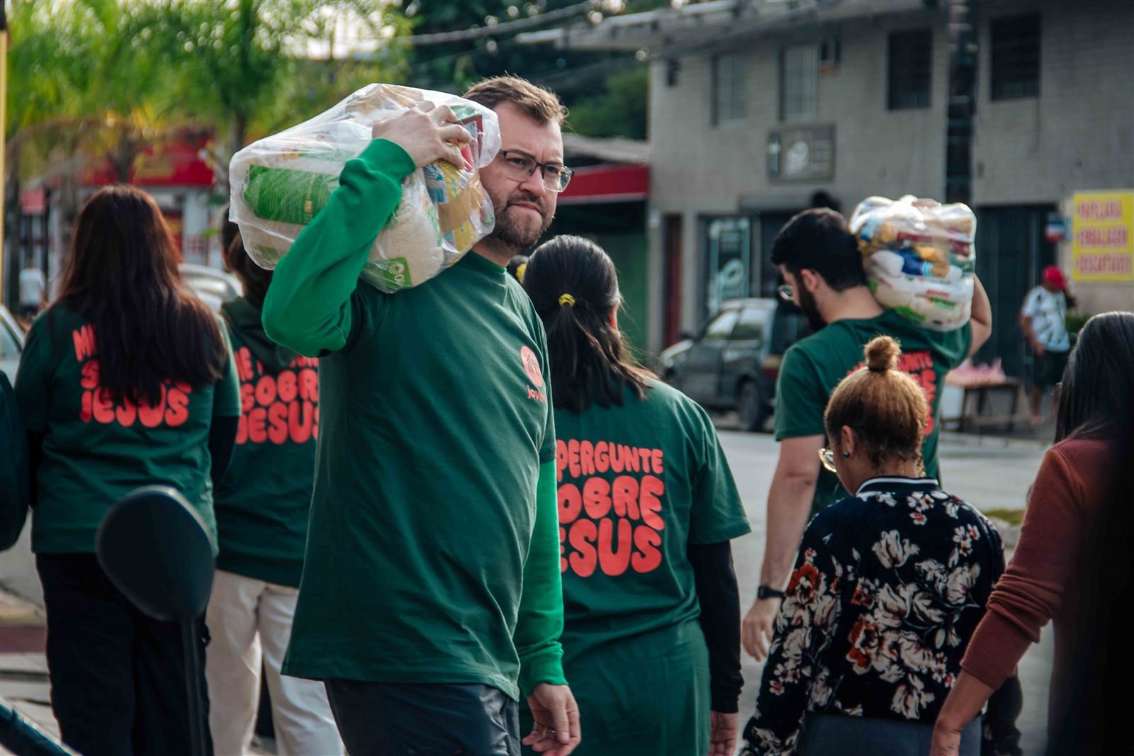 Equipe levando cestas básicas de casa em casa na ação missionária